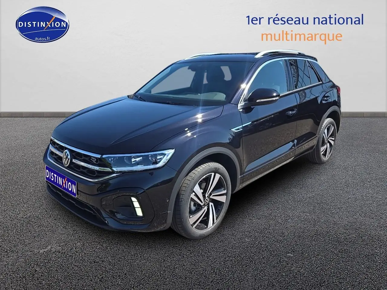 Volkswagen T-Roc noir perle en 3/4 avant droit, avec jantes alliage et barres de toit argentées visibles.