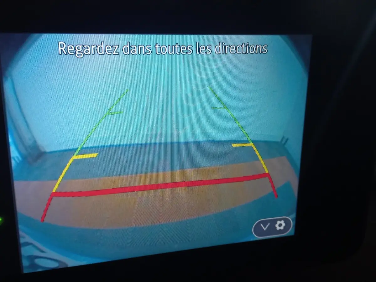 Vue caméra de recul de la Dacia Sandero Extreme+ TCe 110 2024, affichage avec lignes de guidage colorées.