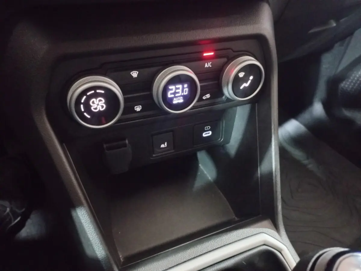 Gros plan sur la console centrale de la Dacia Sandero Extreme+ TCe 110 2024, avec commandes climatisation et ports USB.