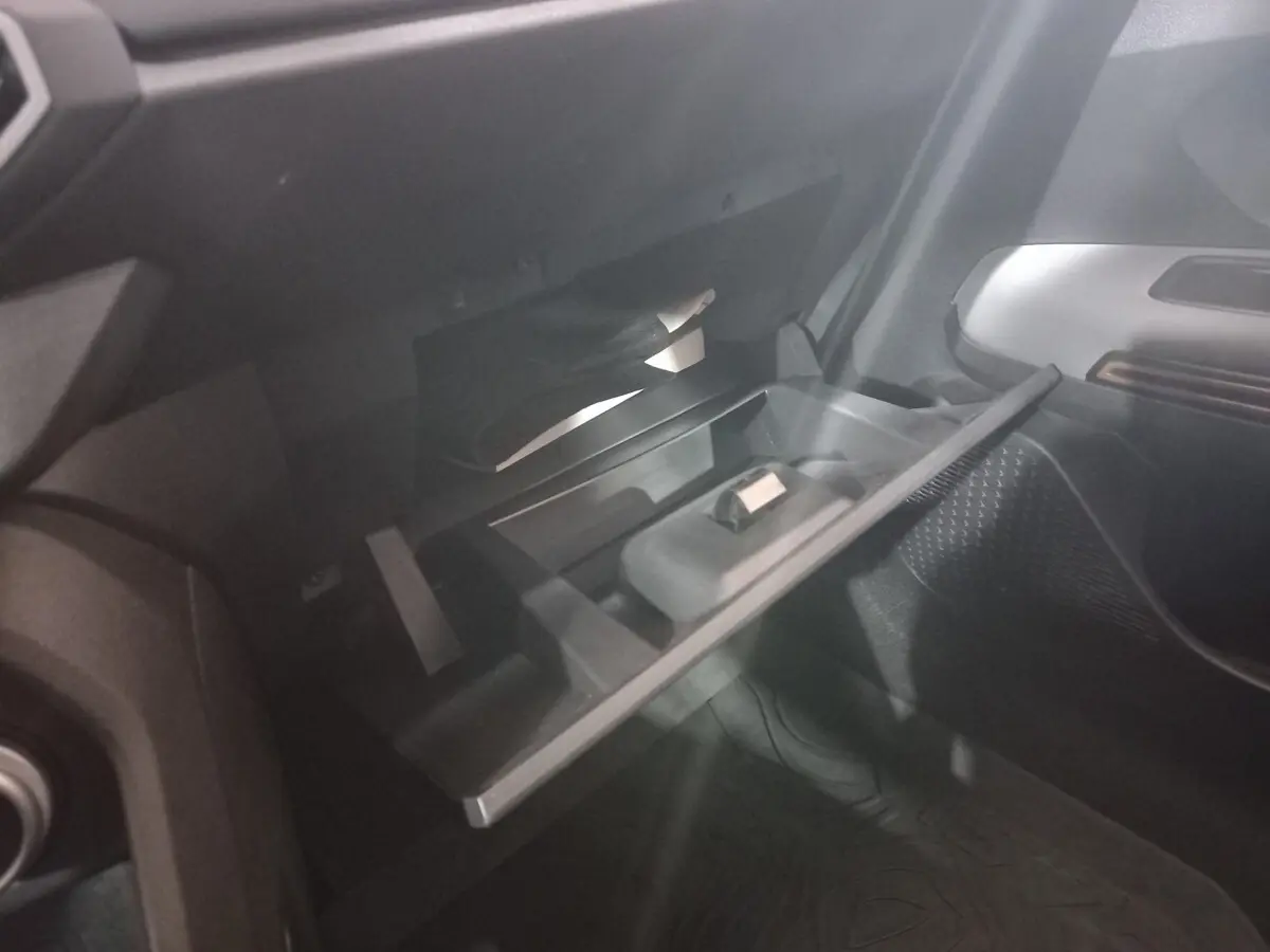 Gant de boîte à gants ouvert côté passager dans l’habitacle sombre d’une Dacia Sandero 2024.
