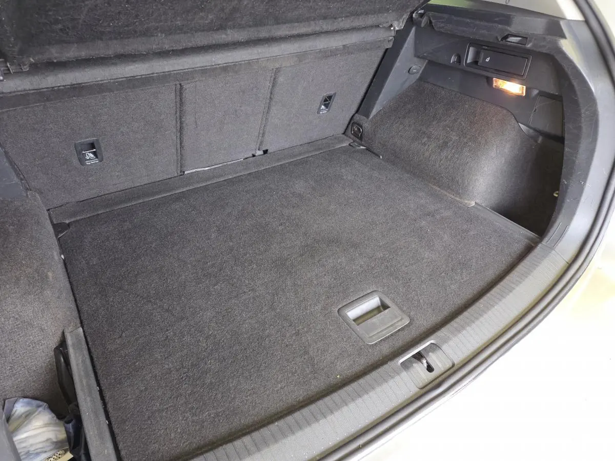 Coffre spacieux du Volkswagen Tiguan gris, vu de dessus avec plancher modulable et éclairage intérieur allumé.