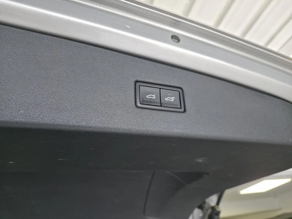 Gros plan sur les boutons de fermeture électrique du coffre du Volkswagen Tiguan gris, vue intérieure du hayon.