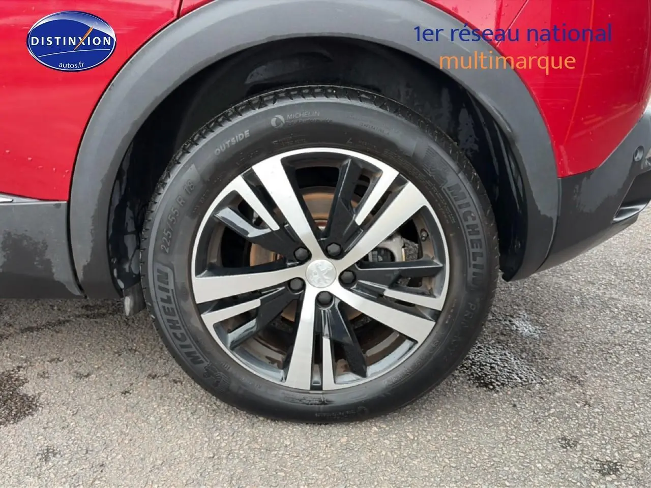 Gros plan sur la roue avant droite avec jante alu bicolore du Peugeot 3008 rouge 2022.