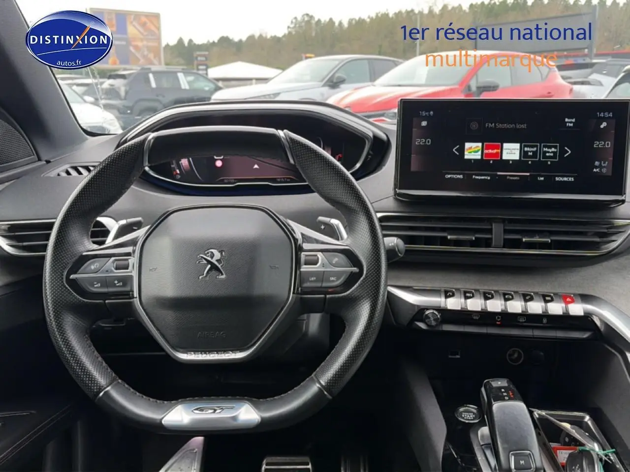 Vue intérieure centrée sur le volant cuir multifonction et l'écran tactile du Peugeot 3008 GT rouge 2022.