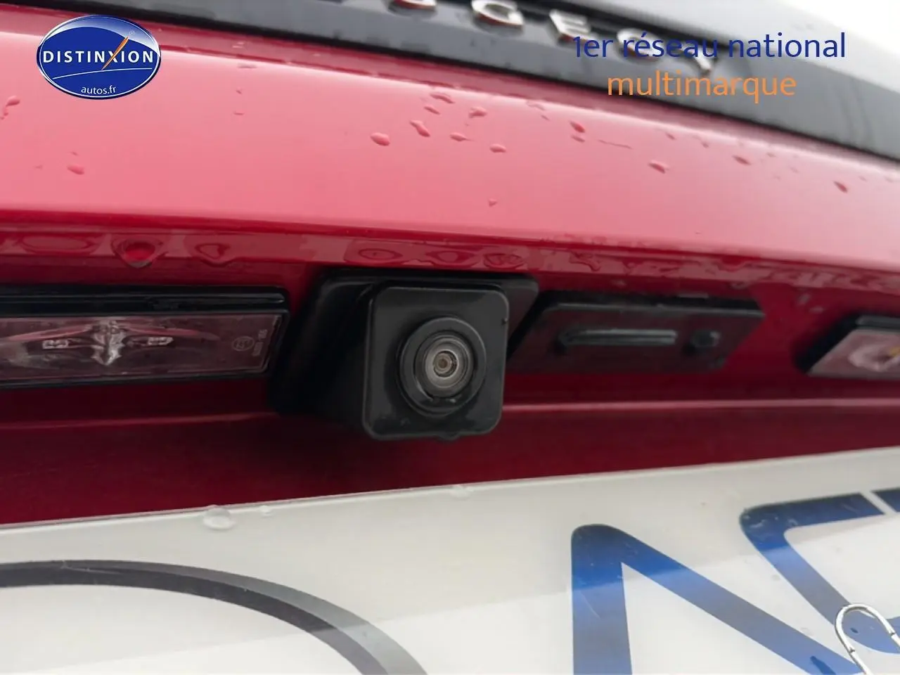 Gros plan sur la caméra de recul intégrée au hayon rouge arrière du Peugeot 3008 1.5 BlueHDi GT EAT8.