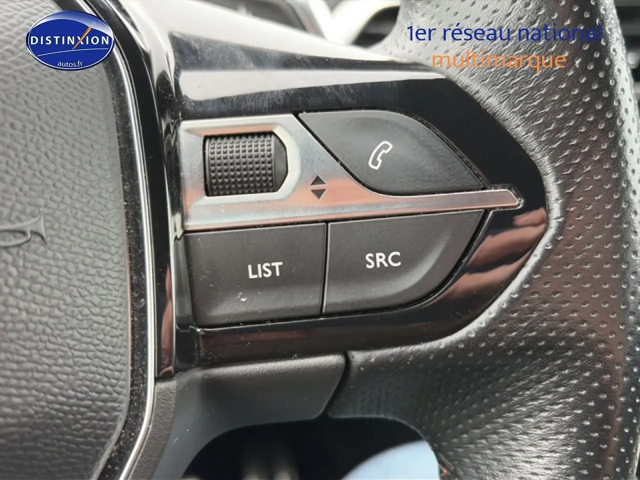 Gros plan sur les commandes audio au volant cuir perforé du Peugeot 3008 rouge 2022, version GT.