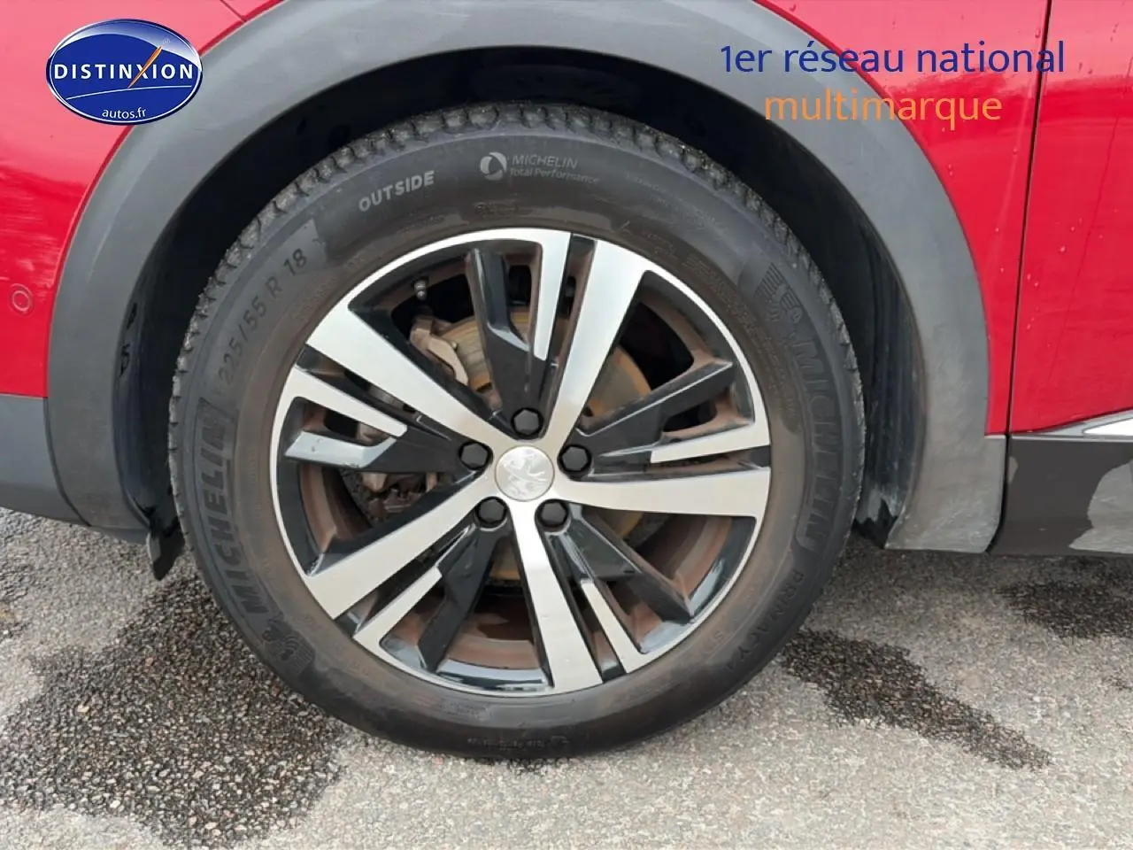 Gros plan sur la roue avant droite avec jante alu bicolore du Peugeot 3008 rouge 2022.