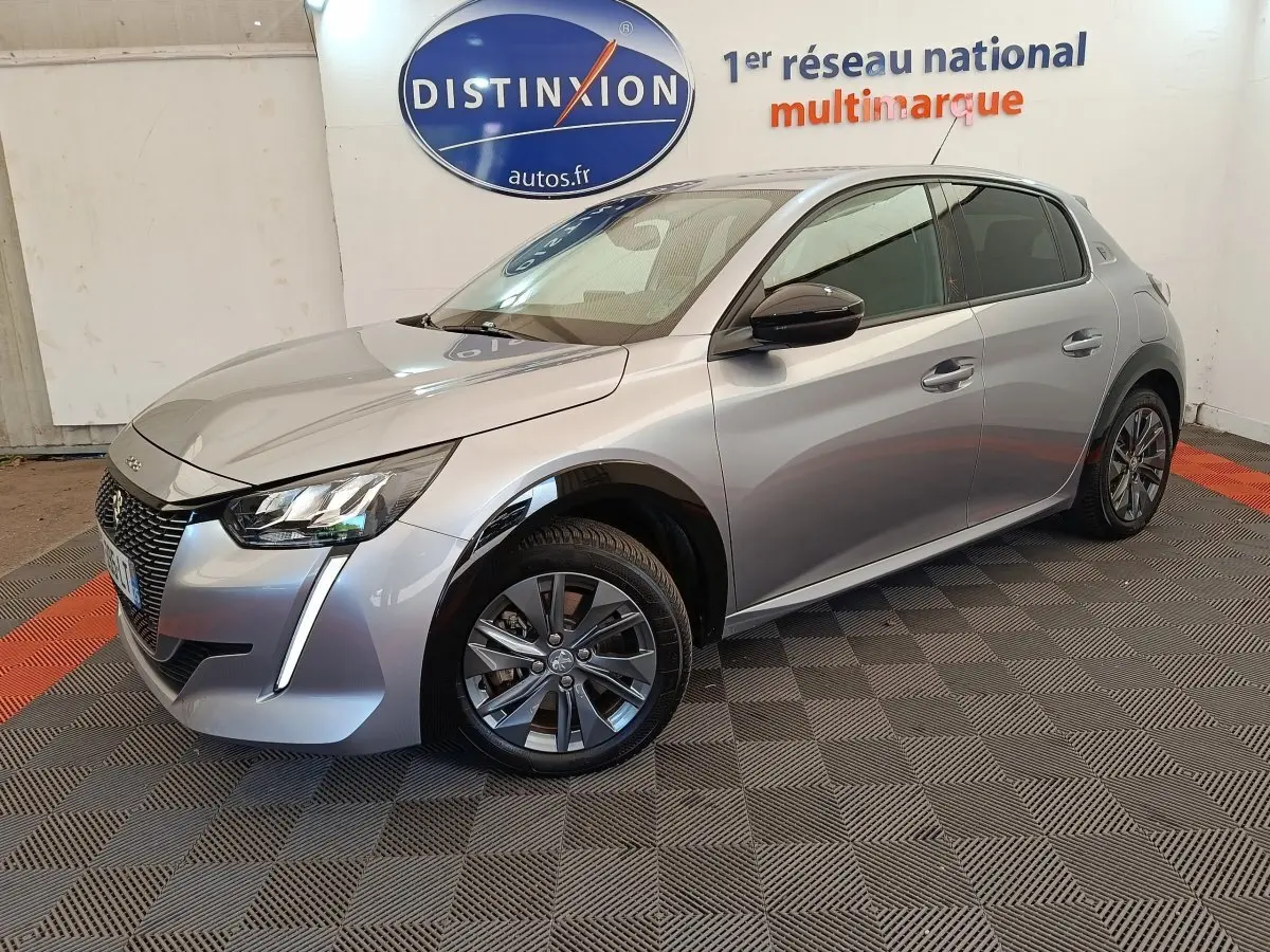 PEUGEOT 208 Electrique gris clair vue 3/4 avant droit, avec jantes alliage et feux LED distinctifs.