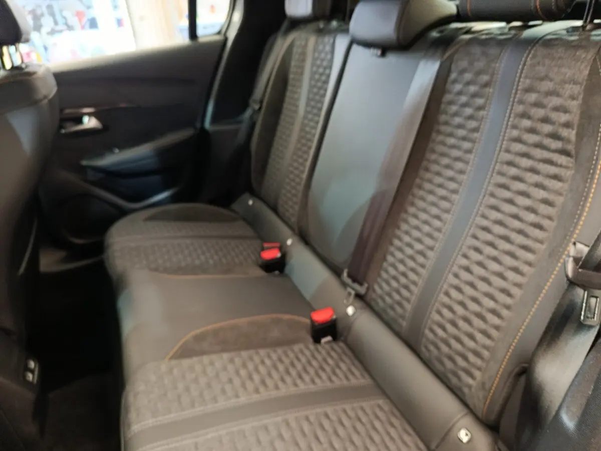 Vue intérieure côté droit sur la banquette arrière gris foncé avec surpiqûres orange de la Peugeot 208 Electrique Roadtrip 2022.