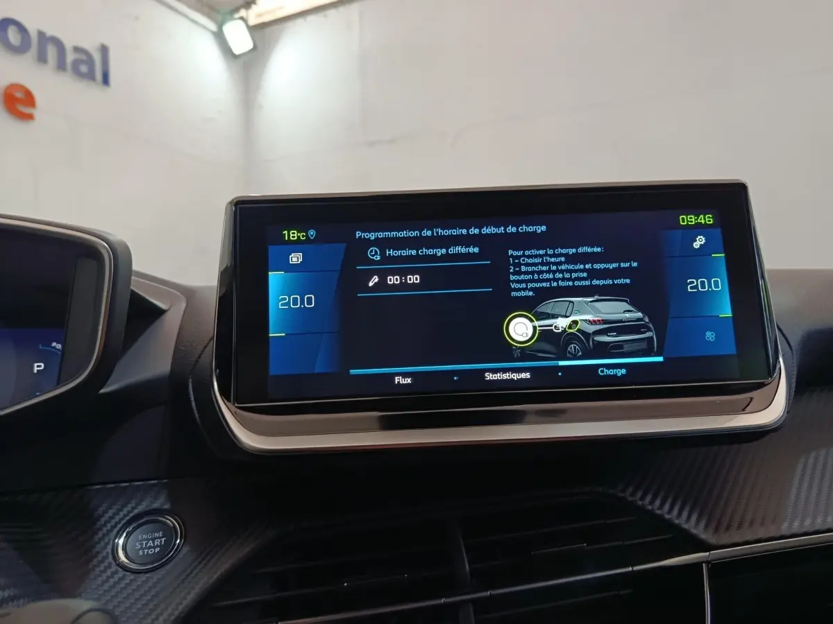 Écran tactile central affichant la programmation de charge sur le tableau de bord d'une Peugeot 208 électrique gris clair.