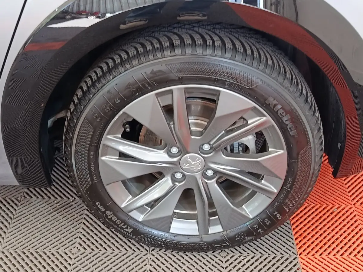 Gros plan sur la roue avant droite gris clair d'une Peugeot 208 Electrique Roadtrip 2022 avec jante alliage moderne.