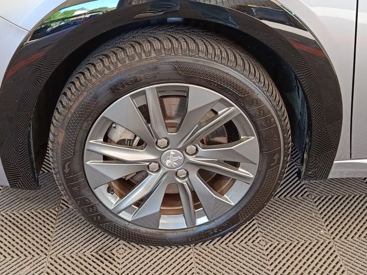 Gros plan sur la roue avant droite gris clair d'une Peugeot 208 Electrique ROADTRIP 2022 avec jante alliage.
