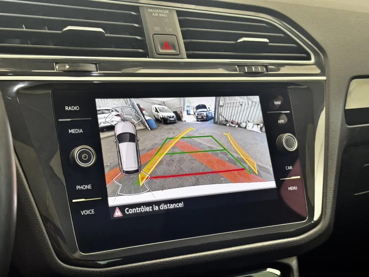 Écran tactile central du Volkswagen Tiguan 2021 montrant la caméra de recul avec guidage de trajectoire coloré.