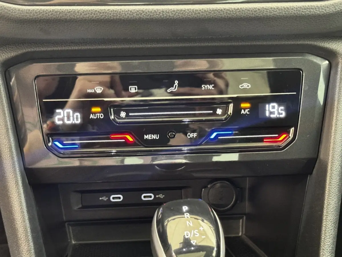 Détail du panneau de climatisation digital et levier de vitesse automatique dans un Volkswagen Tiguan gris clair 2021.