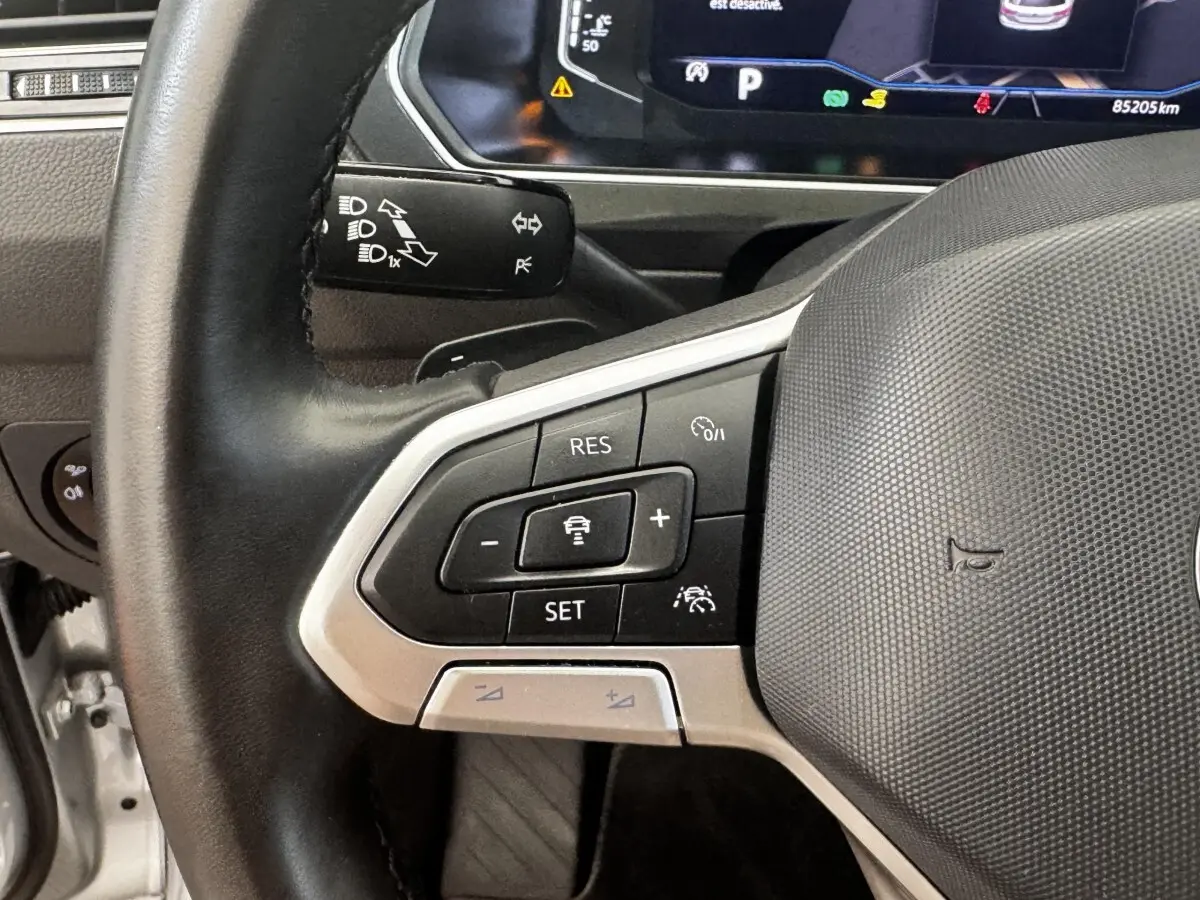 Gros plan sur le volant cuir côté gauche du Volkswagen Tiguan 1.5 TSI 150 DSG7 Elegance avec commandes multifonctions.