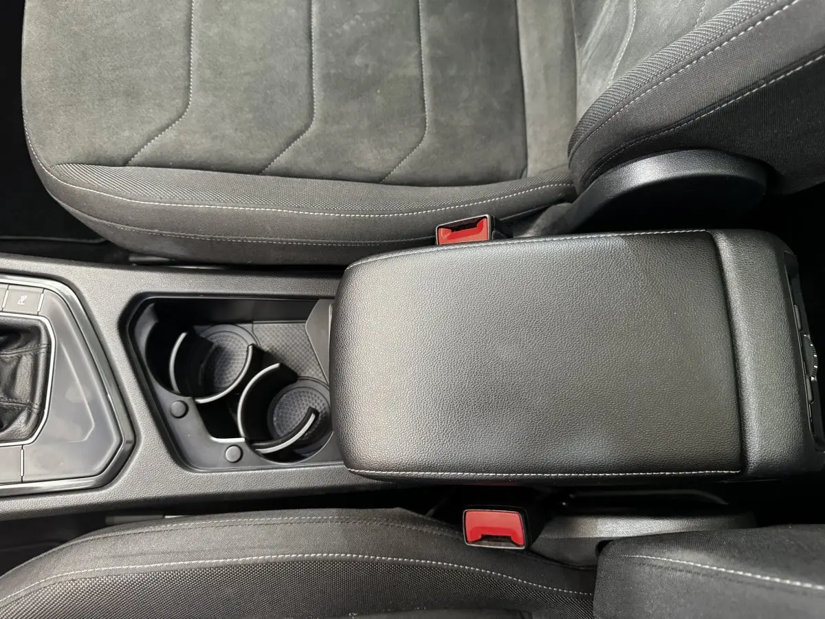 Vue rapprochée de la console centrale et des sièges gris foncé du Volkswagen Tiguan 1.5 TSI 150 DSG7 Elegance 2021.