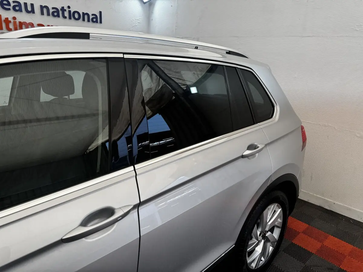 Vue côté droit arrière d'un Volkswagen Tiguan gris clair 2021 avec vitres teintées et jantes alliage.