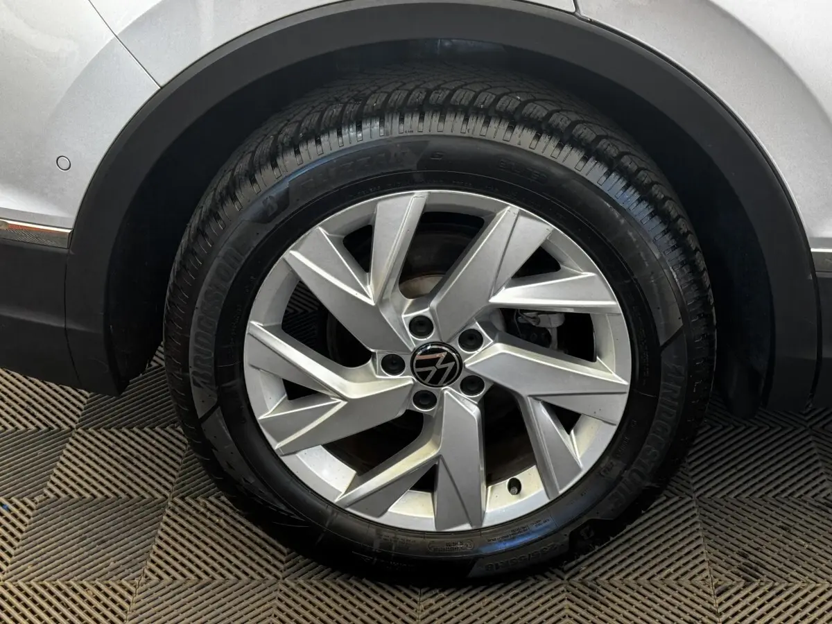 Gros plan sur la roue avant droite gris clair du Volkswagen Tiguan 1.5 TSI 150 DSG7 Elegance avec jante alliage distinctive.