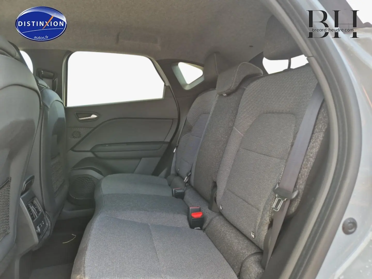 Vue intérieure côté droit montrant la banquette arrière grise du Renault Captur 1.6 E-Tech hybride 2025.