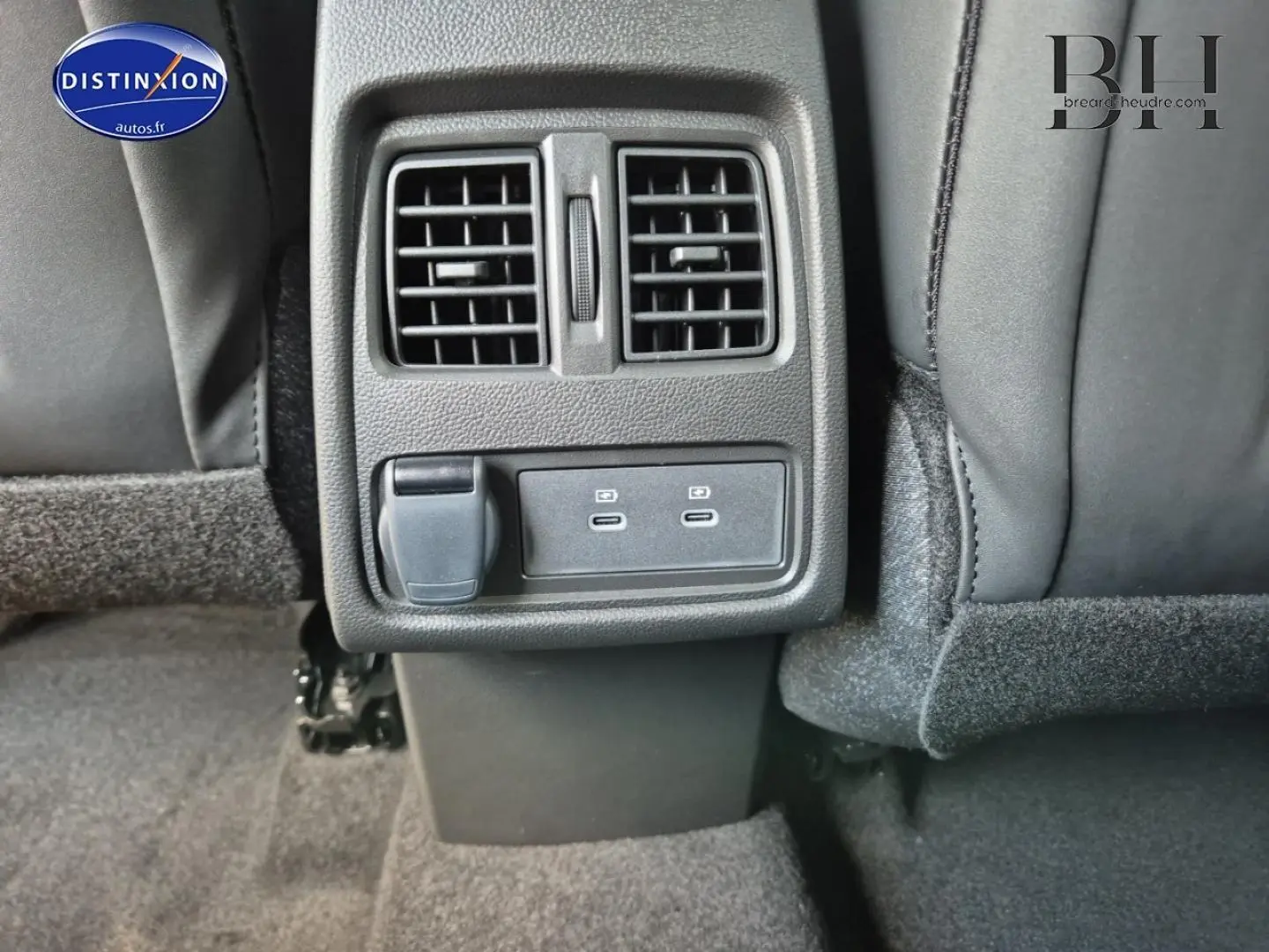 Vue rapprochée des aérateurs arrière et des ports USB-C noirs dans l’habitacle du Renault Captur bleu Iron 2025.