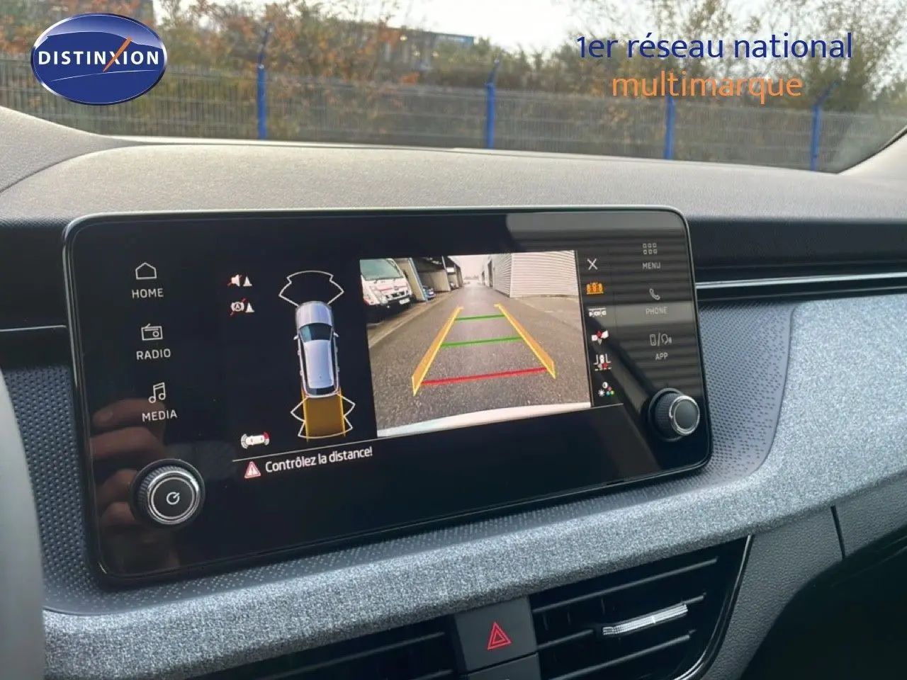 Écran tactile central montrant la caméra de recul du Skoda Kamiq gris argent, tableau de bord en tissu gris.