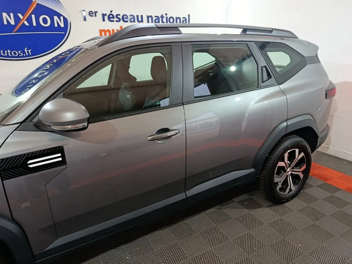 Vue latérale côté gauche du Dacia Bigster gris foncé avec jantes alliage et rétroviseurs électriques intégrés.