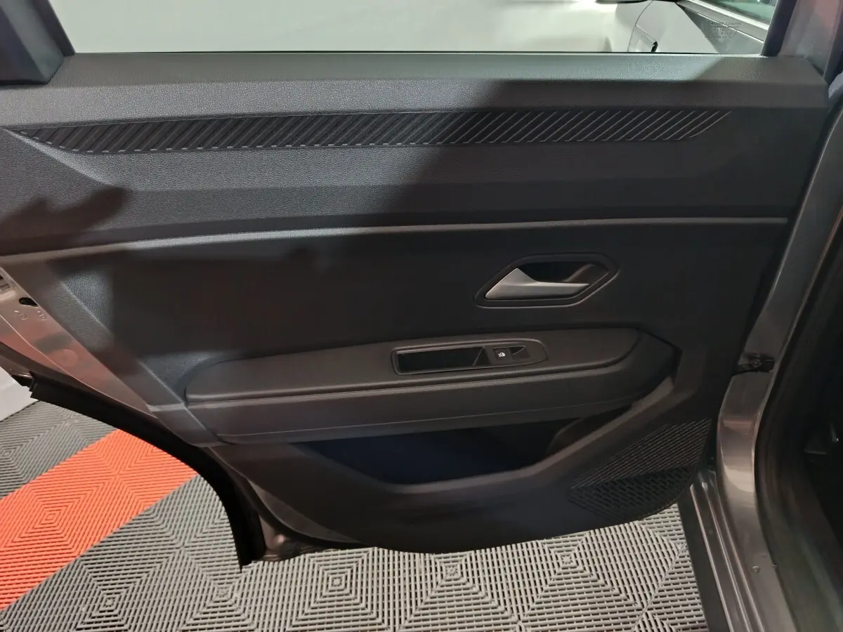 Vue intérieure de la porte arrière droite grise du Dacia Bigster 2025, avec poignée et commande de vitre électrique.