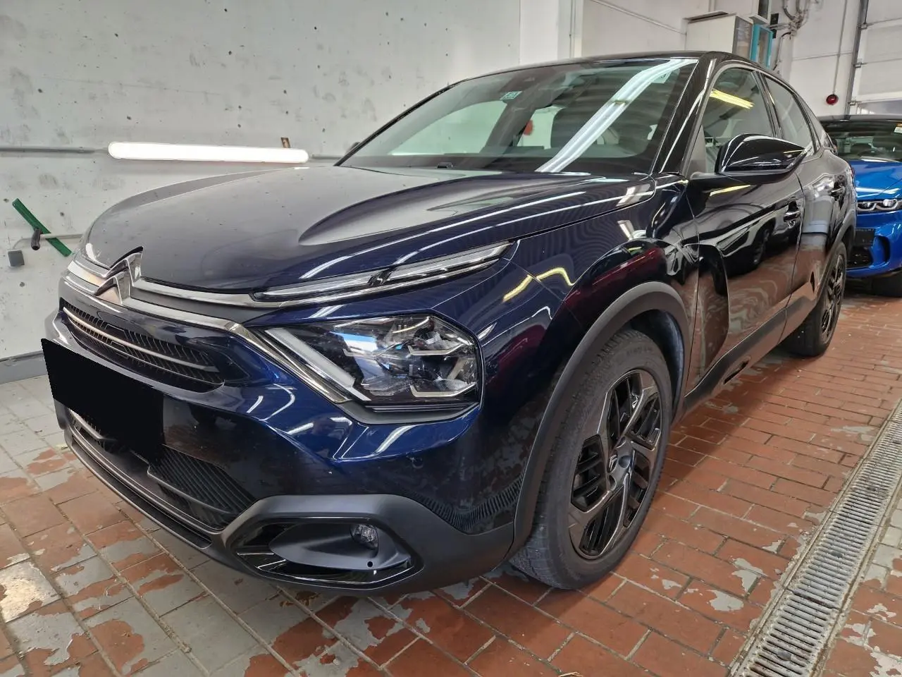 Citroën C4 2024 bleu Eclipse vue 3/4 avant droit avec toit noir Perla et jantes alliage noires.