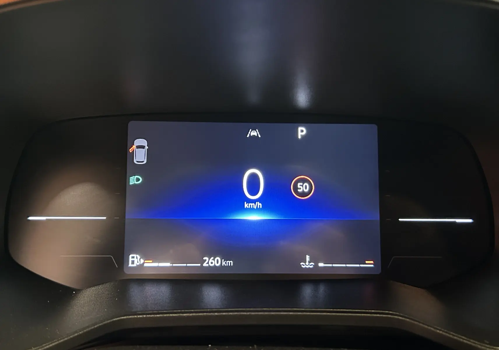 Affichage numérique du tableau de bord de la Renault Clio V blanc, montrant la vitesse à 0 km/h et l'autonomie à 260 km.