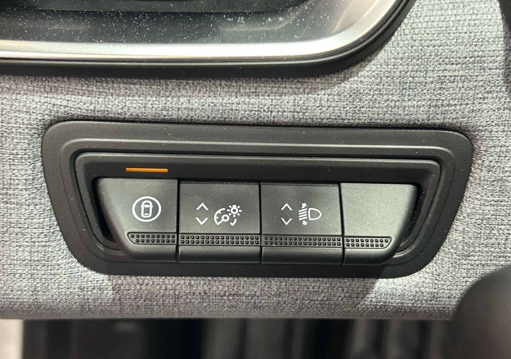 Gros plan sur les boutons de réglage d’éclairage et de verrouillage intérieur de la Renault Clio V blanche.