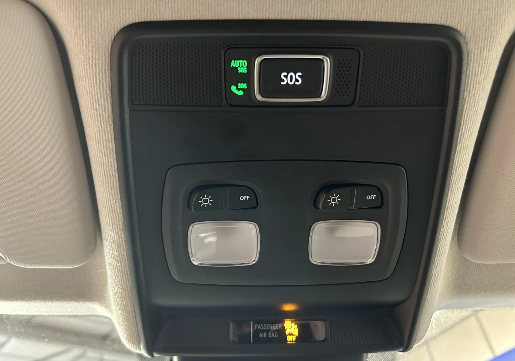 Vue en gros plan du plafonnier intérieur avec boutons d’éclairage et alerte SOS sur Renault Clio V blanche.