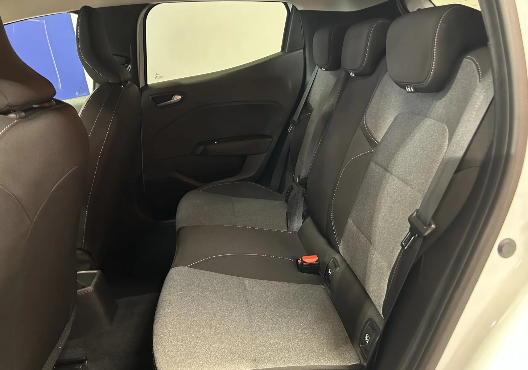 Vue intérieure côté droit des sièges arrière en tissu gris et noir de la Renault Clio V blanche, version TCE 90CH CVT Evolution.
