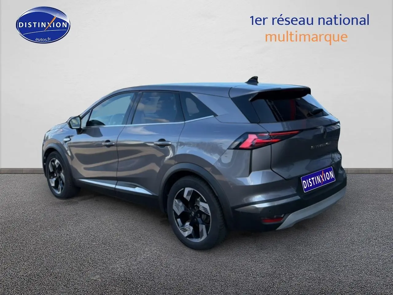 Renault Symbioz 2025 gris métallisé, vue 3/4 arrière droit, avec feux arrière LED et jantes noires distinctives.