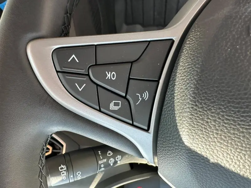 Gros plan sur les commandes au volant noir et argent du DACIA JOGGER 2025, côté gauche du volant.