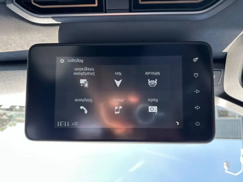 Écran tactile central du tableau de bord du Dacia Jogger blanc, affichant les options multimédia et navigation.