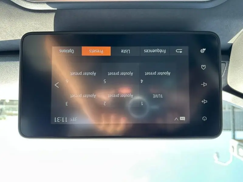 Écran tactile central du tableau de bord du Dacia Jogger blanc, affichant les presets radio en mode FM.