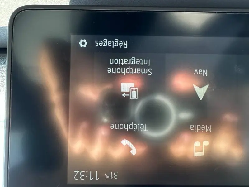 Écran tactile central du tableau de bord du Dacia Jogger blanc, affichant les options smartphone, téléphone et navigation.