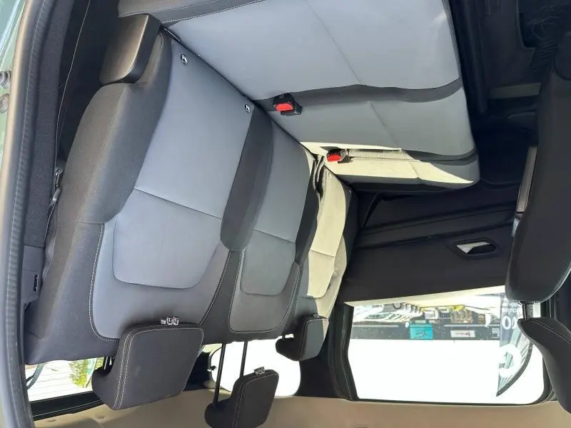 Vue intérieure de la banquette arrière grise et noire du Dacia Jogger 1.6 hybrid 7 places, montrant les appuie-têtes et ceintures.