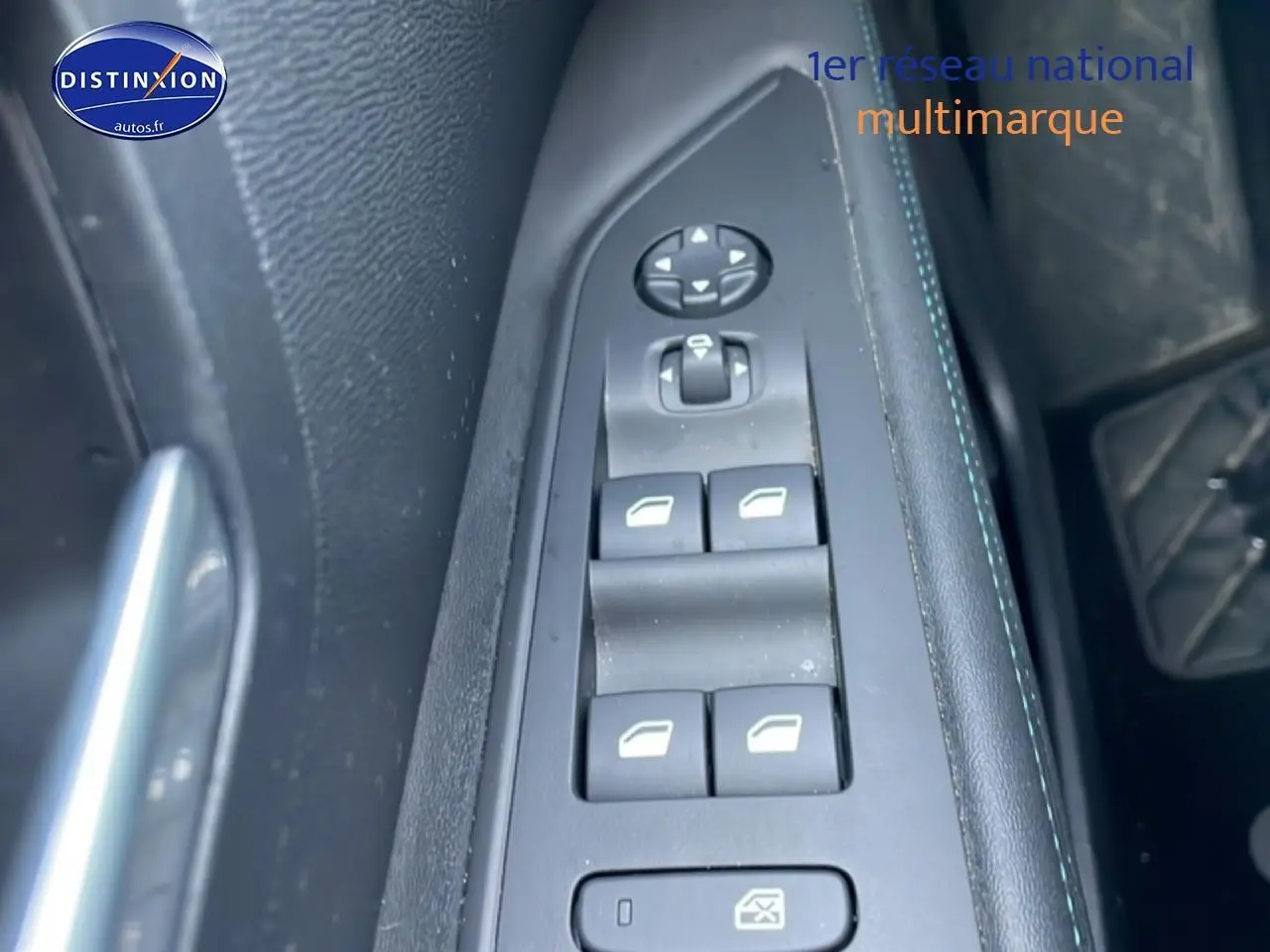 Gros plan sur les commandes des vitres électriques côté conducteur du Peugeot 3008 bleu, version hybride 2024.
