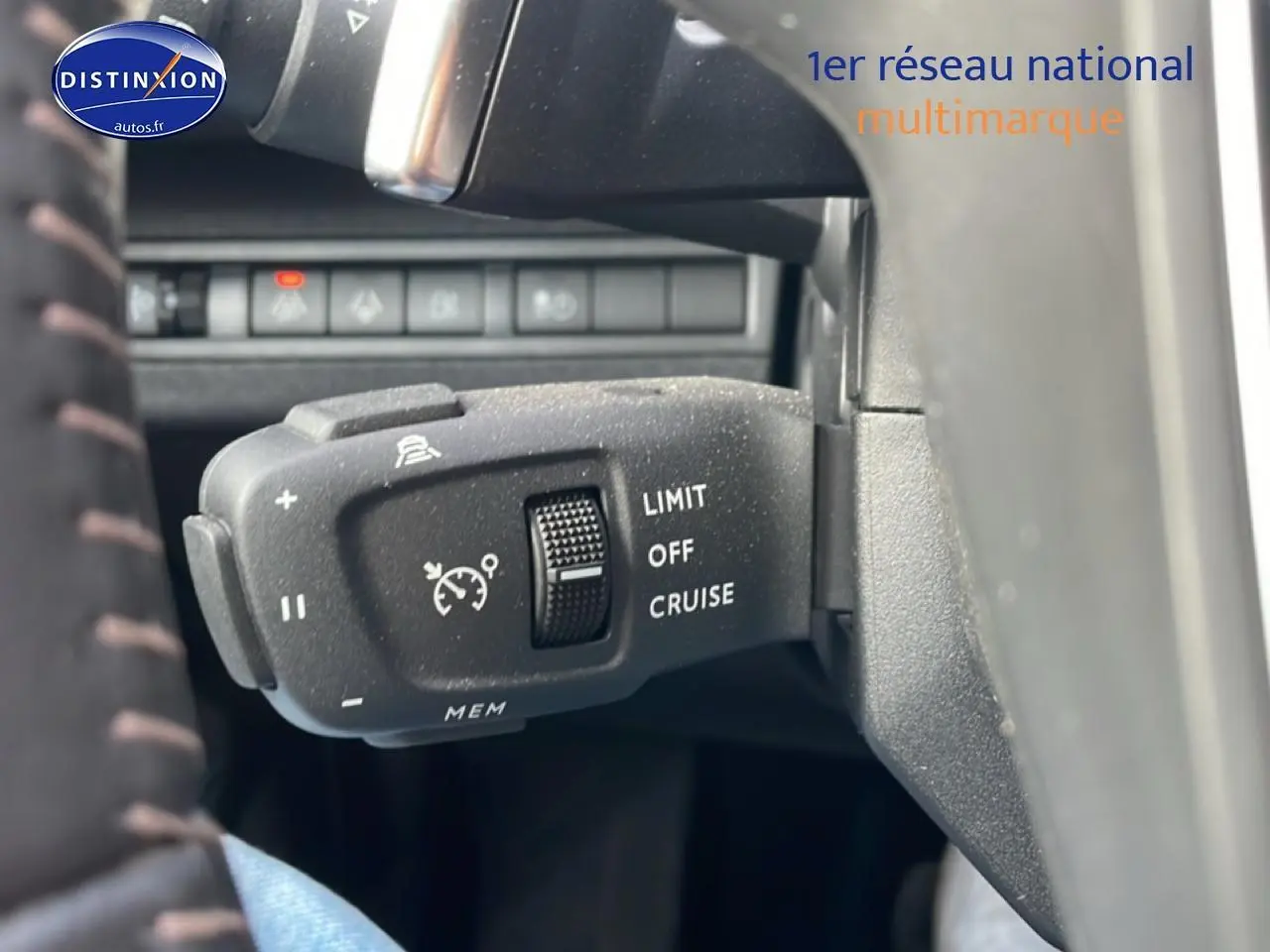 Gros plan sur la commande de régulateur de vitesse au volant d’un Peugeot 3008 bleu 2024 hybride.