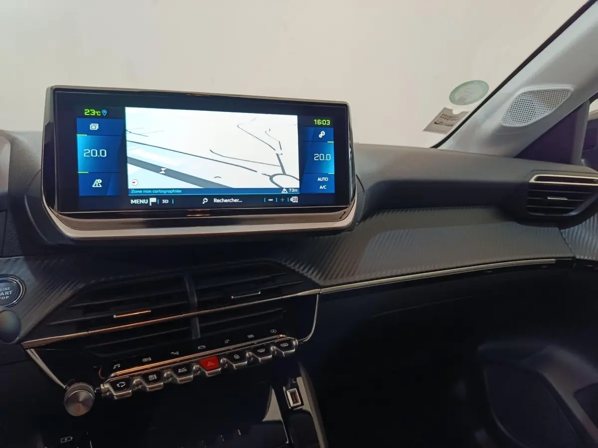 Vue intérieure du tableau de bord de la Peugeot 208 électrique gris clair avec écran tactile central et commandes modernes.