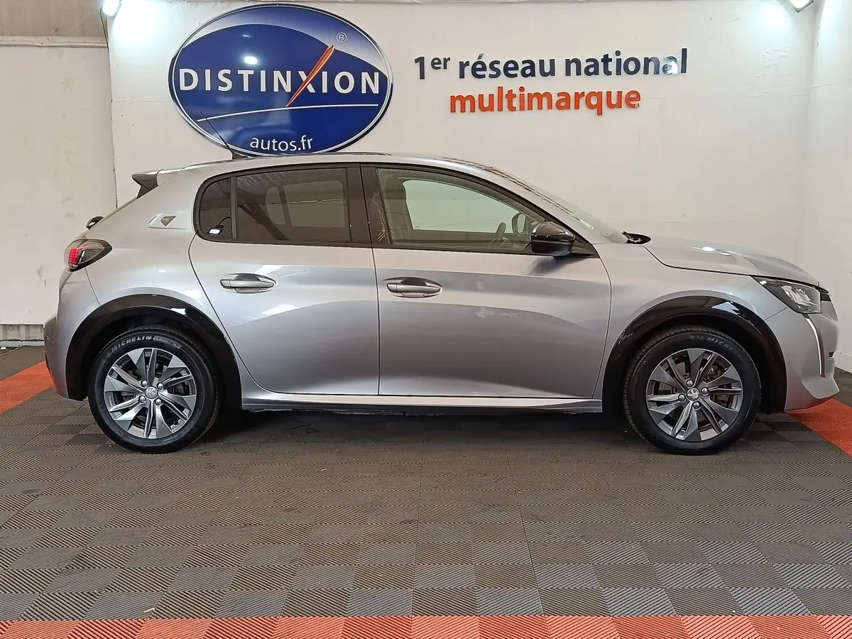 Peugeot 208 Electrique ROADTRIP gris clair vue de profil côté gauche, avec jantes alliage et poignées chromées.