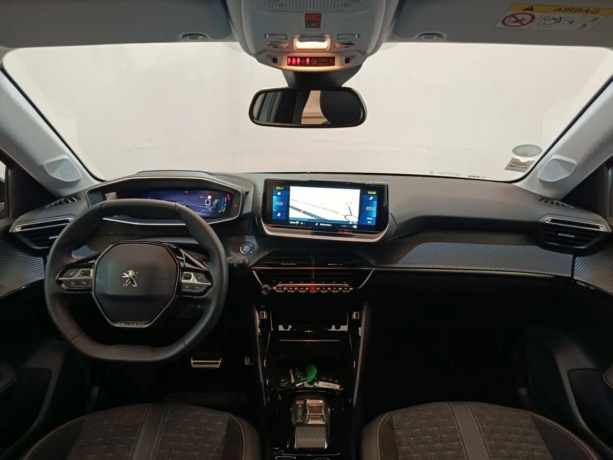 Vue frontale de l'intérieur de la Peugeot 208 Electrique ROADTRIP 2022, tableau de bord noir avec écran tactile central.