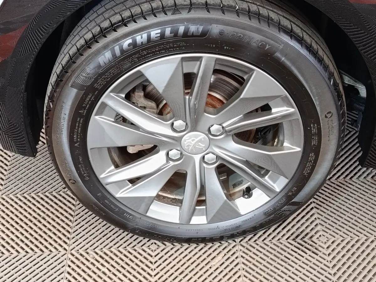 Gros plan sur la roue avant droite de la Peugeot 208 Electrique Roadtrip gris clair avec jante alliage et pneu Michelin.