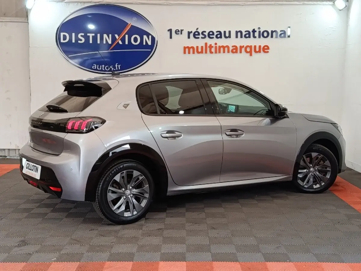Peugeot 208 Electrique ROADTRIP gris clair vue de profil côté droit, feux arrière LED et jantes alliage visibles.