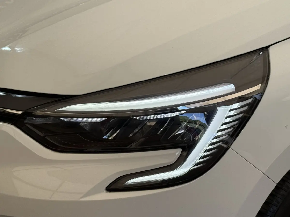 Gros plan sur le phare avant droit blanc de la Renault Clio Evolution TCe 100 GPL 2023 avec LED distinctive.