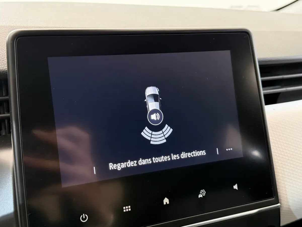 Écran tactile central de Renault Clio 2023 affichant l'alerte de détection d'obstacles avec message de sécurité.