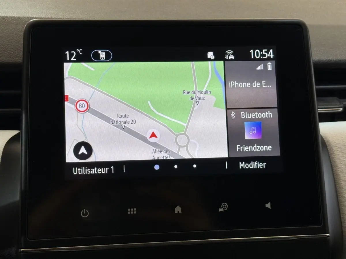 Écran tactile central de la Renault Clio blanc 2023 affichant la navigation et la connexion Bluetooth.