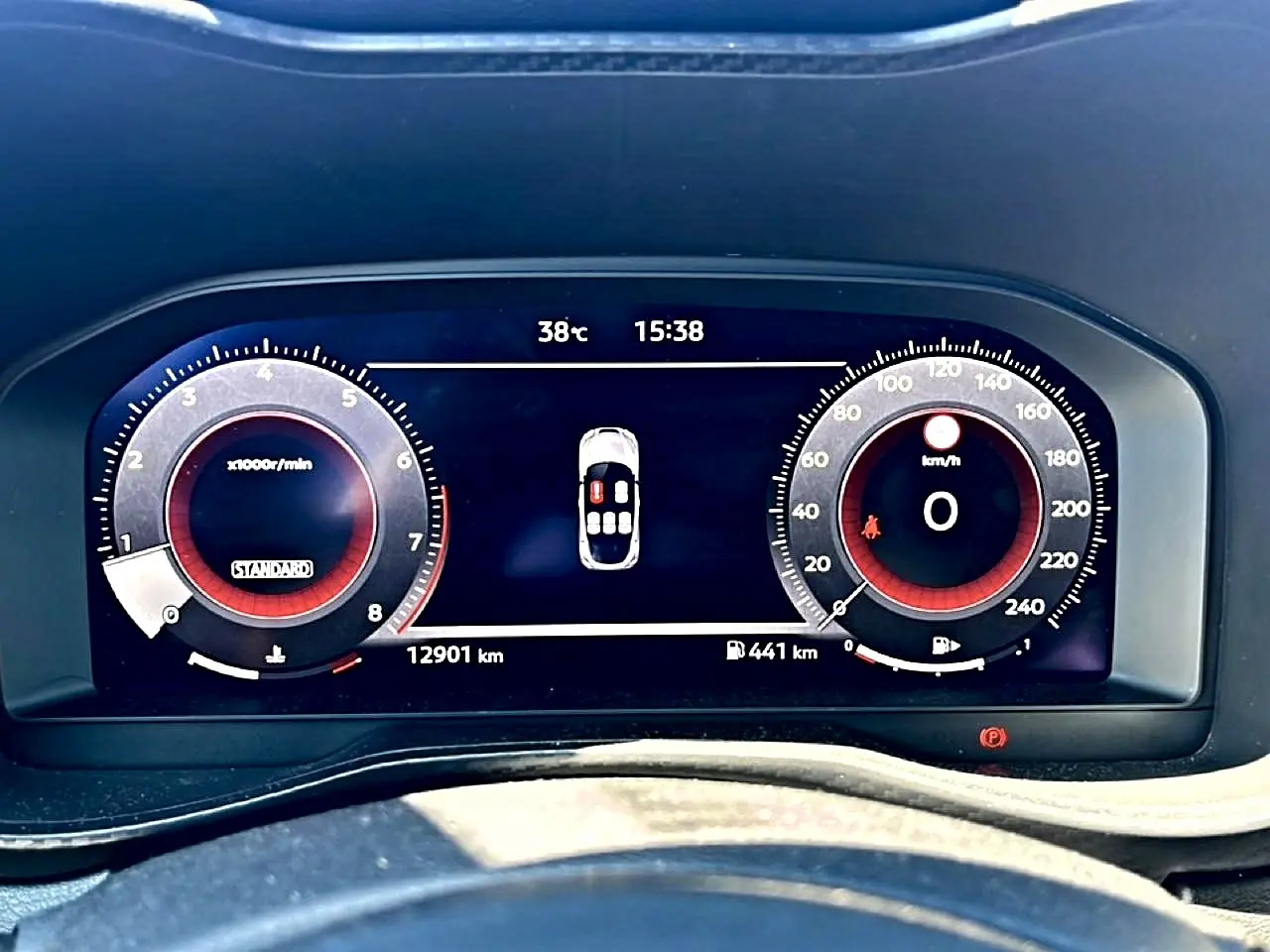 Vue rapprochée du tableau de bord numérique du Nissan Juke gris, affichant compte-tours et vitesse à 0 km/h.
