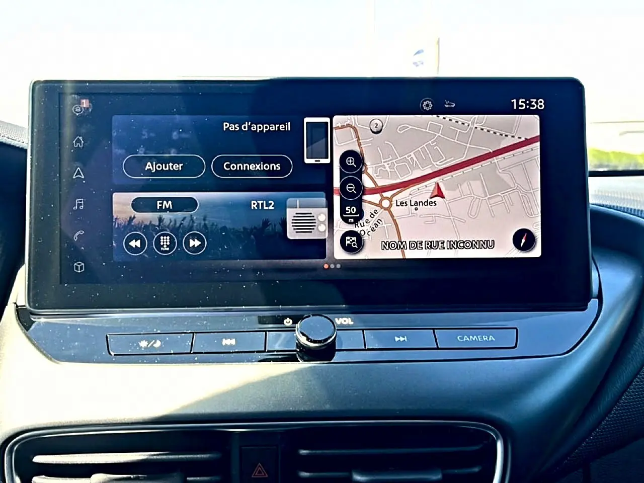 Écran tactile central du tableau de bord du Nissan Juke 2025 affichant navigation et radio FM.